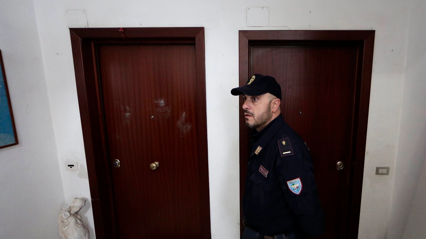 Ostia, un agente davanti alla porta di Silvano Spada crivellata di proiettili (Lapresse)