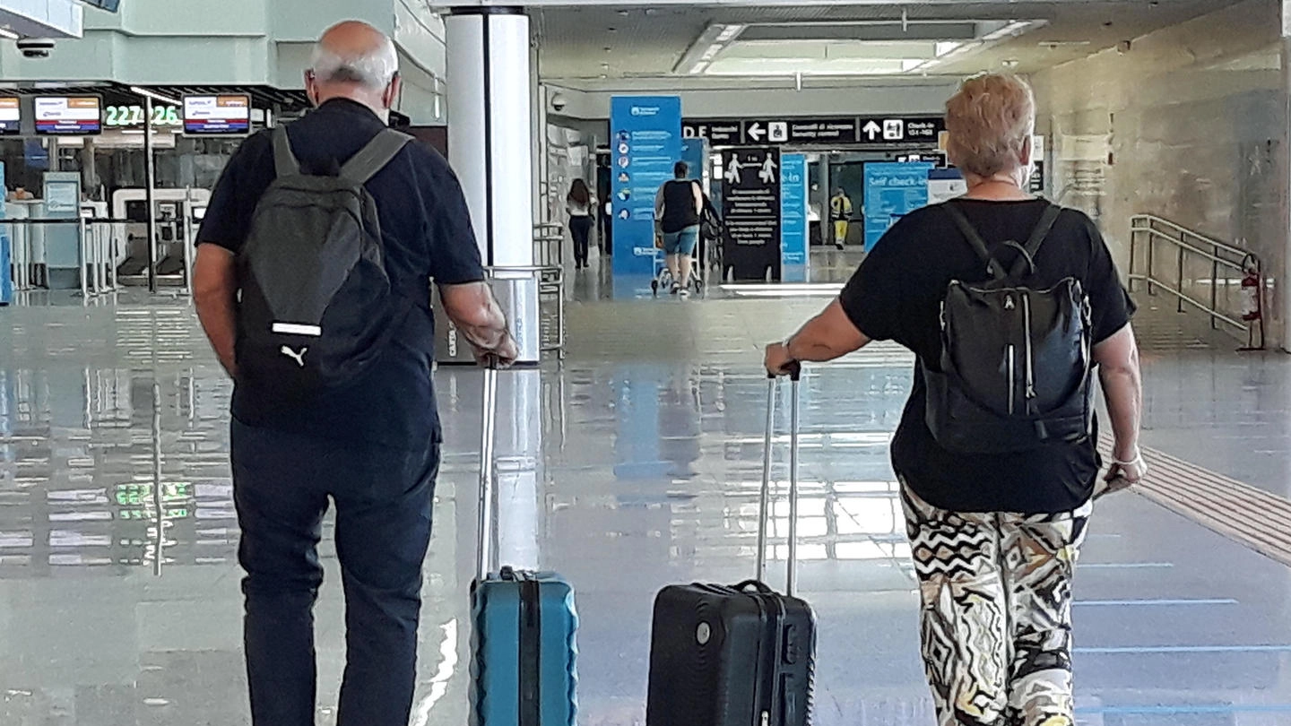 Due viaggiatori all'aeroporto 'Leonardo da Vinci' (Ansa)