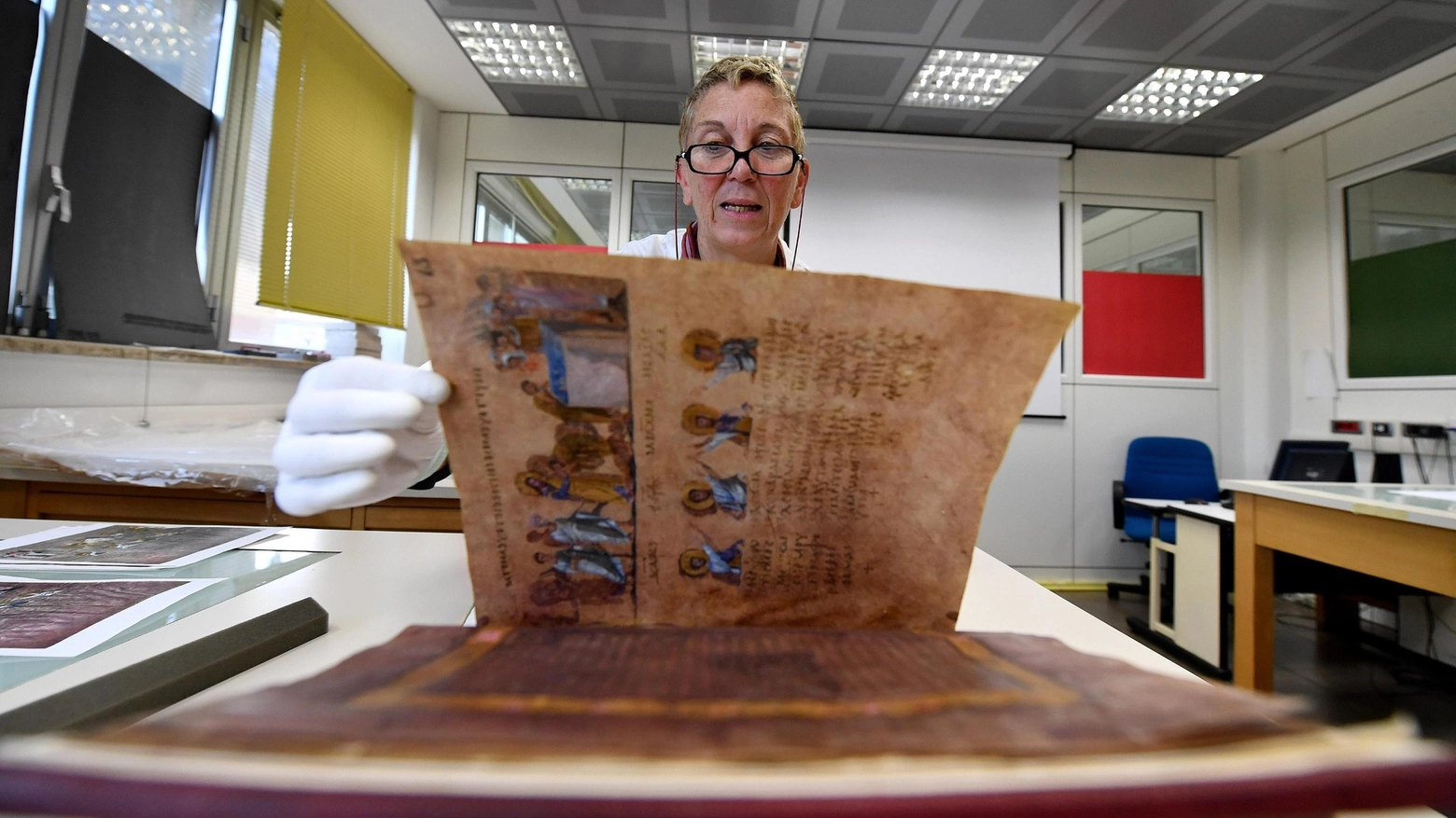 Le mani protette dai guanti per toccare il Codex Purpureus (foto Ansa) 