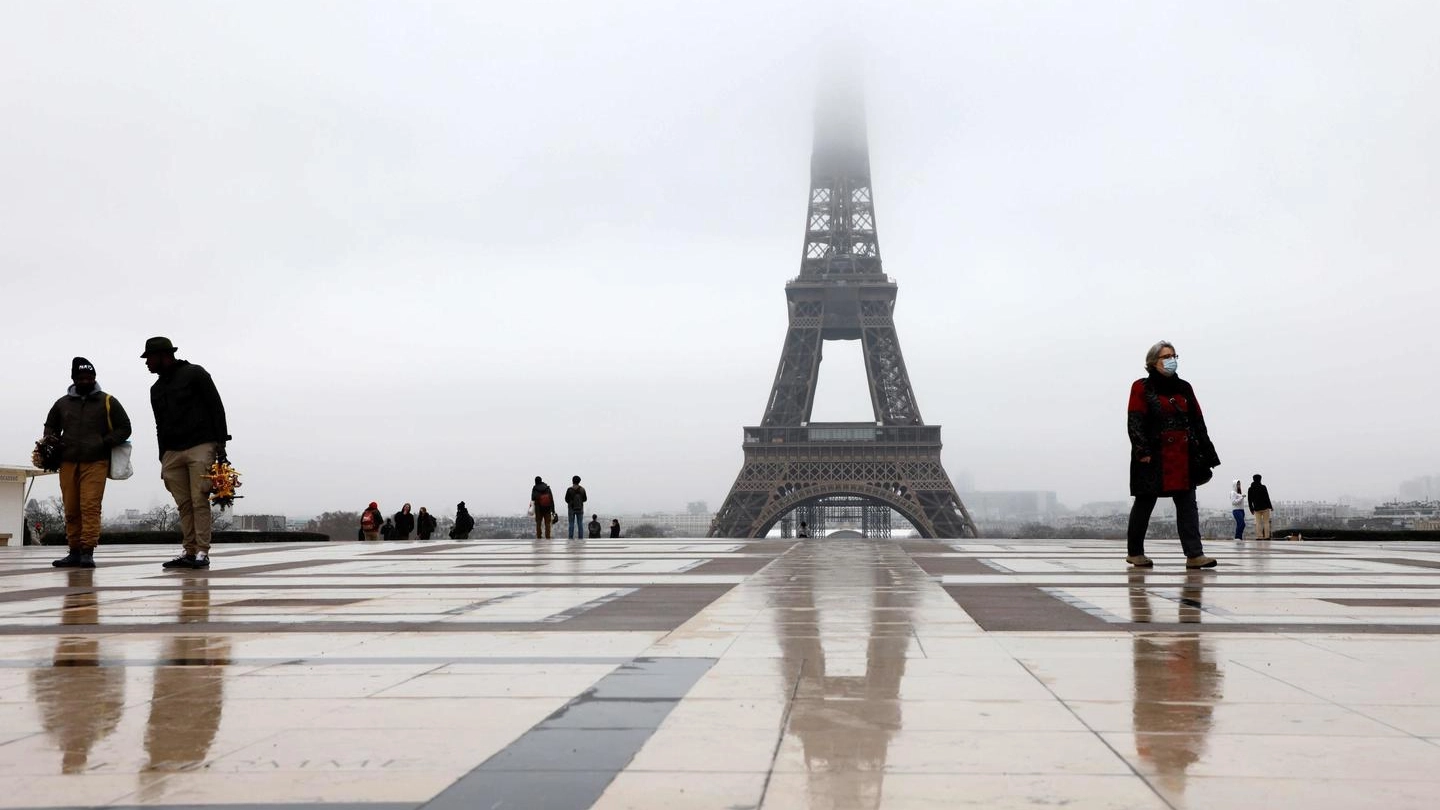 Parigi, alcune persone con le mascherie nei pressi della Torre Eiffel (Ansa)