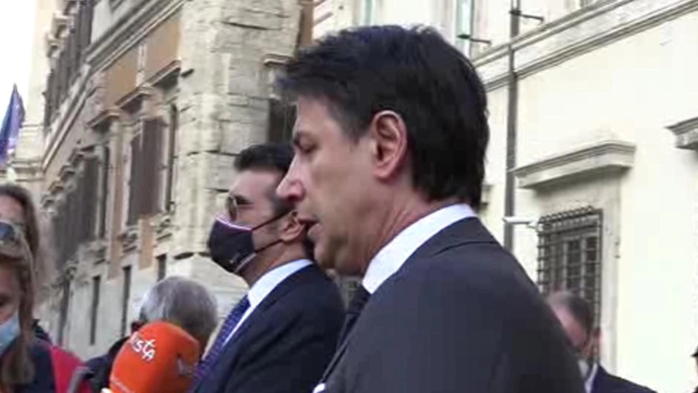 Il premier Conte parla con i giornalisti fuori da Palazzo Chigi (Ansa)