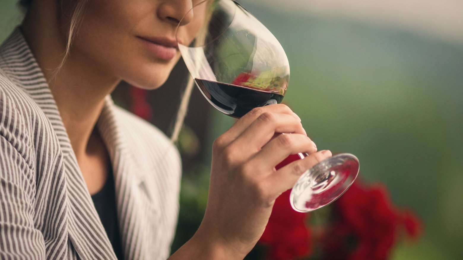 Una donna beve un bicchiere di vino, foto generica