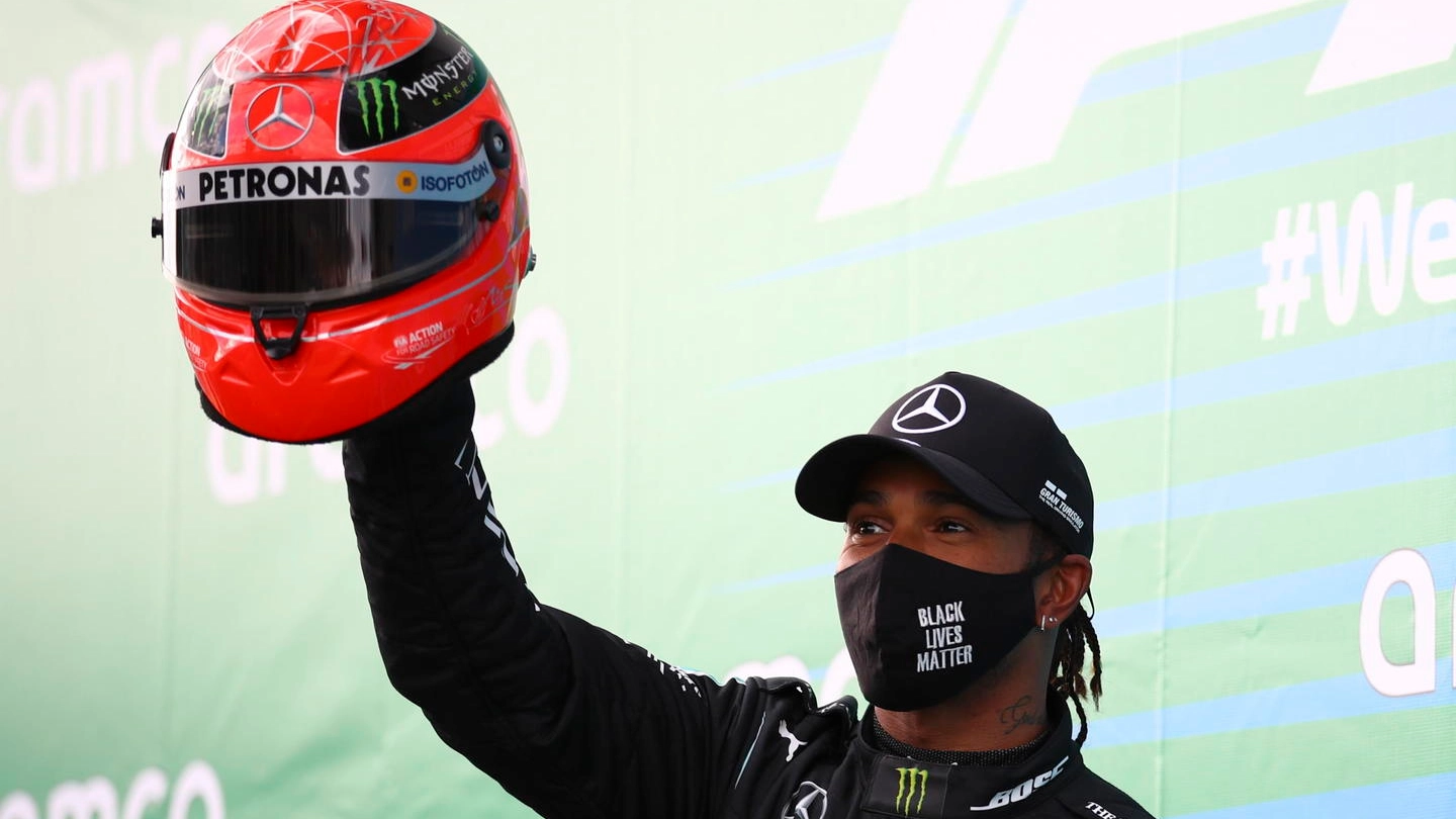 Lewis Hamilton solleva il casco di Michael Schumacher datogli dal figlio Mick (Ansa)