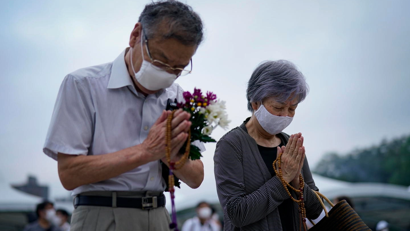 Due persone pregano davanti al Peace Memorial Park di Hiroshima (Ansa)