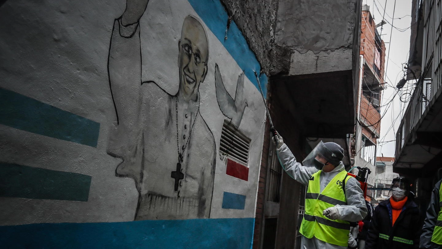 Sanificazione di un muro con l'immagine di Papa Francesco a Buenos Aires (Ansa)