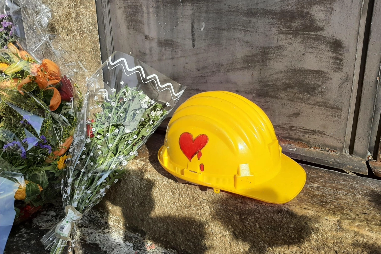 Strage di Brandizzo: un casco con un cuore rosso che sanguina davanti alla stazione