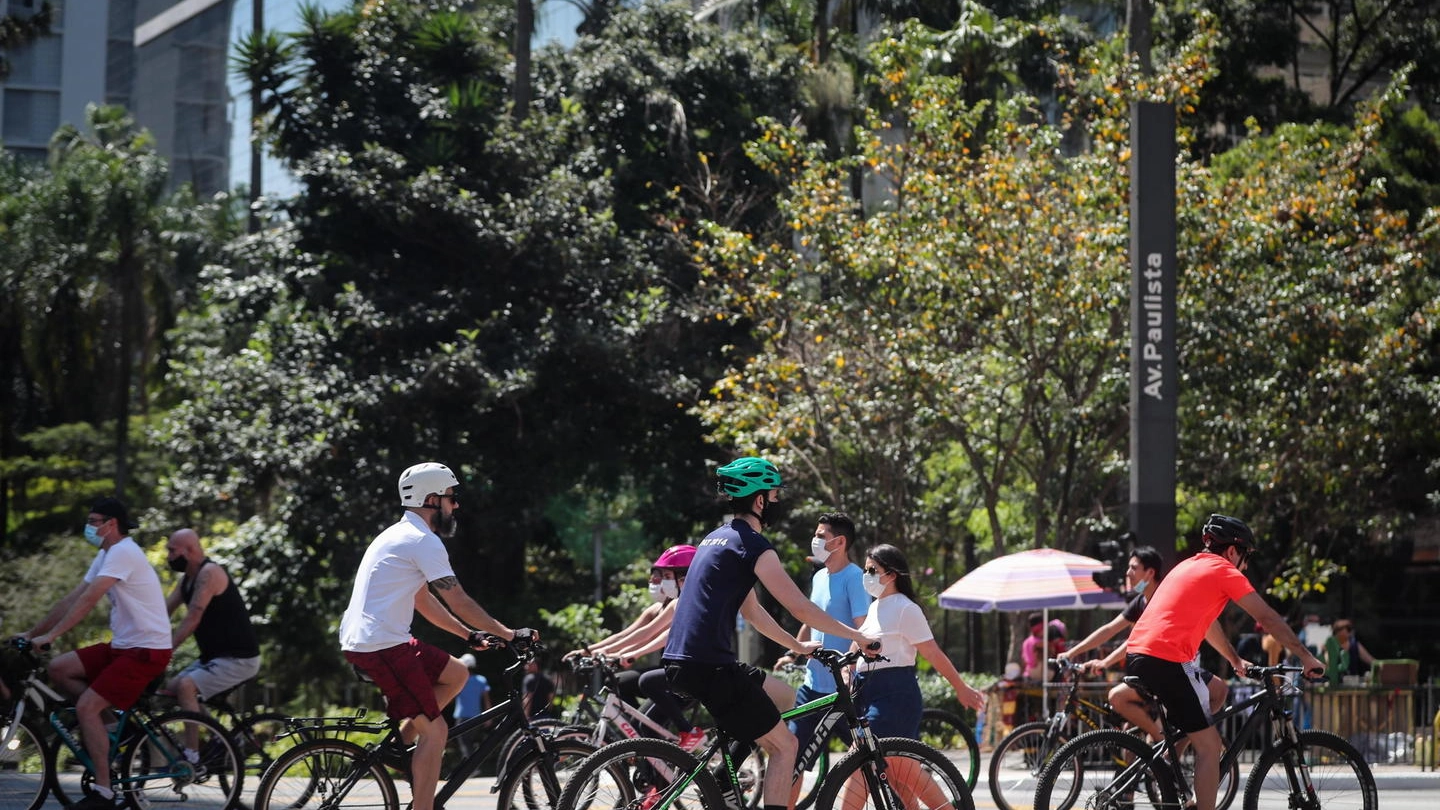 Ciclisti con la mascherina a San Paolo in Brasile (Ansa)