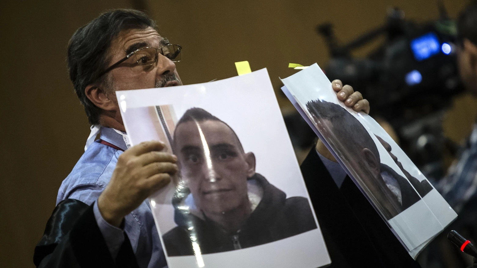 L'avvocato della famiglia Cucchi mostra le foto di Stefano durante il processo (Ansa)