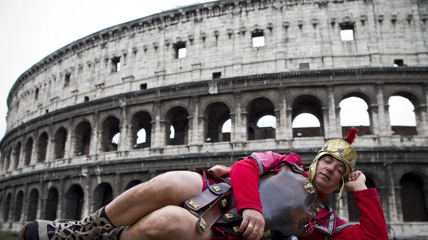 Un "Centurione" posa di fronte al Colosseo a Roma (Ansa)