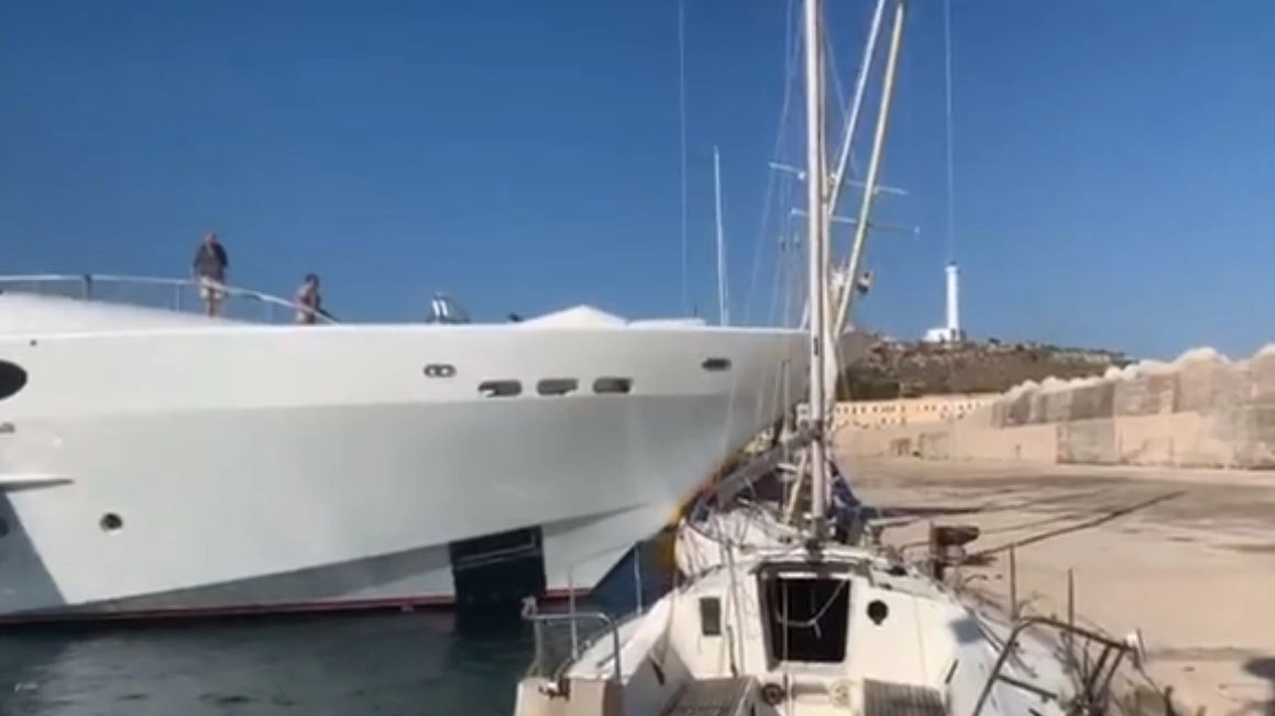 Un mega yacht schiaccia contro la banchina un barca vela (frame da video su Facebook)