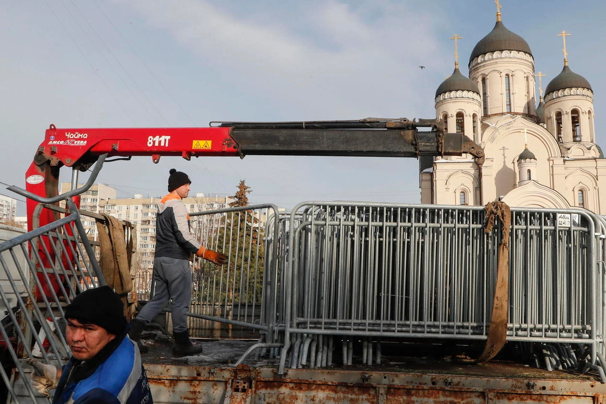 Gli operai municipali scaricano le transenne fuori dalla chiesa dell’Icona della Madre di Dio a Mosca