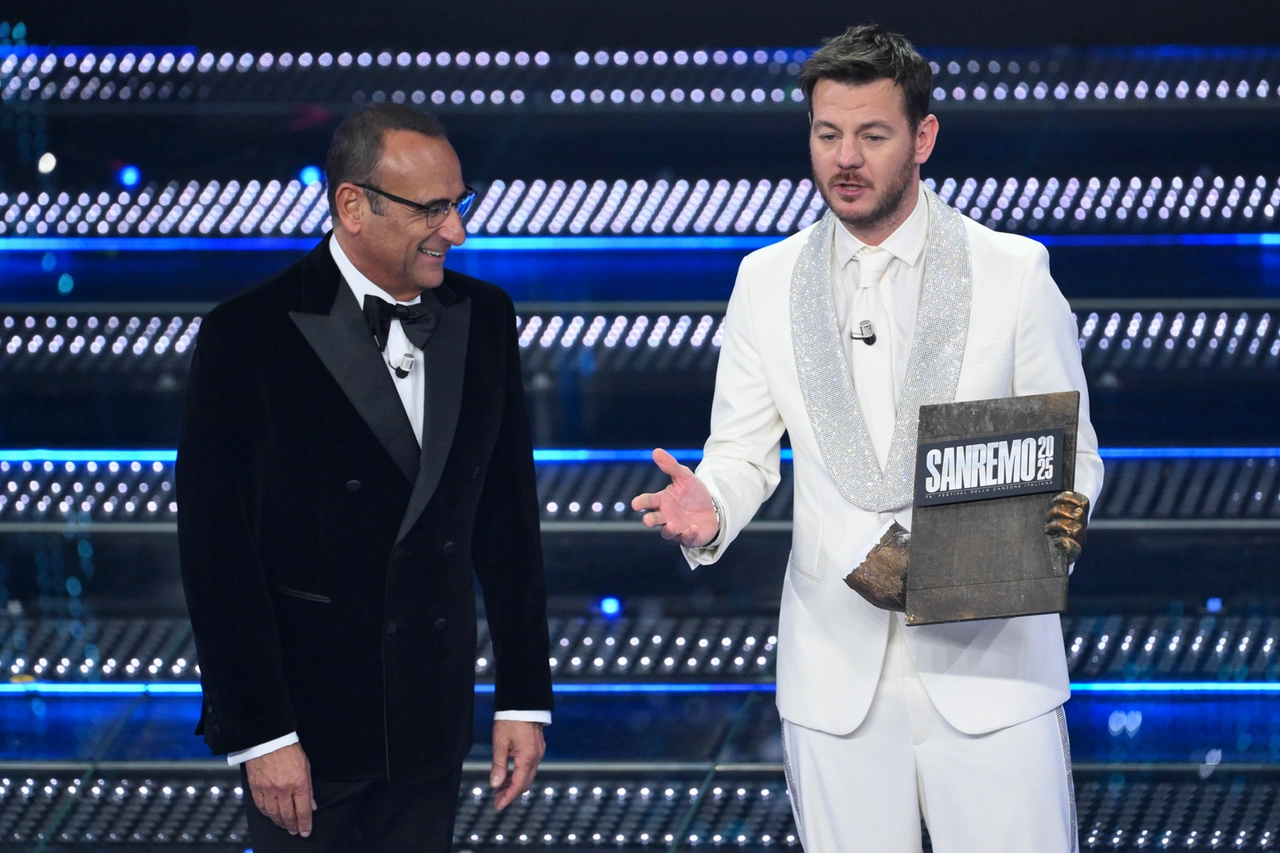 Alessandro Cattelan consegna un reperto della statua del dopo festival a Carlo Conti