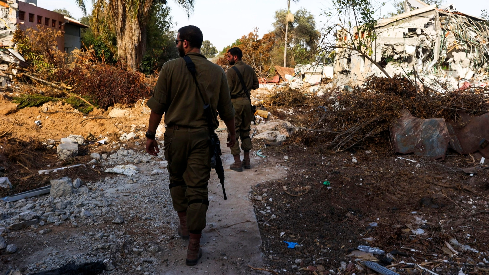 Soldati israeliani tra le case distrutte del Be'eri Kibbutz (Ansa)