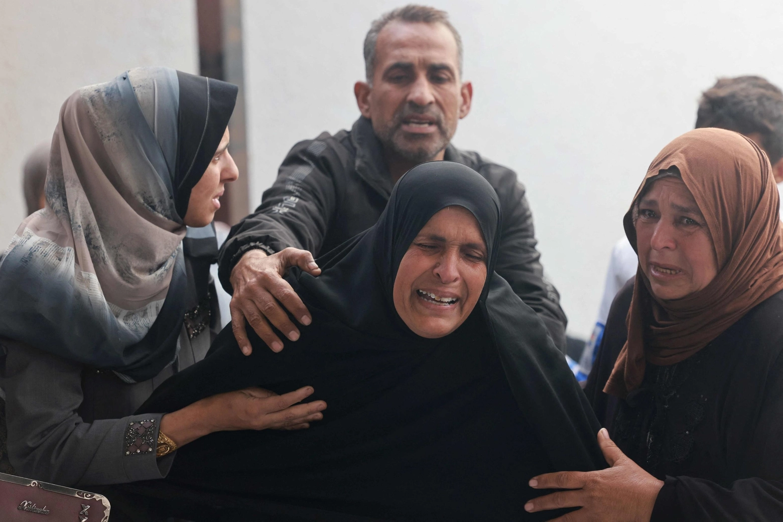 I palestinesi piangono i corpi dei parenti uccisi nei bombardamenti israeliani, all'ospedale al-Najar di Rafah (Ansa)