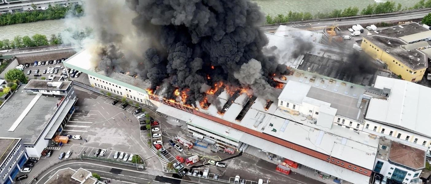 Incendio devastante nella sede di Alpitronic a Bolzano: capannone in fiamme, evacuata scuola, intervento dei vigili del fuoco per salvare la produzione di colonne di ricarica per auto elettriche.