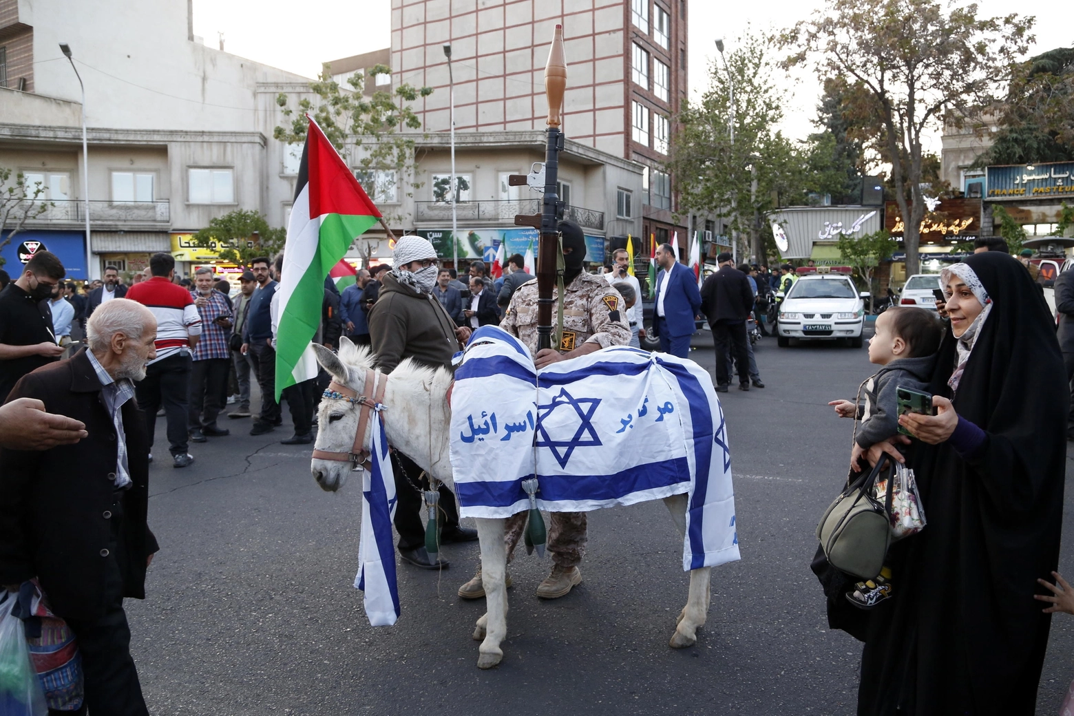 Un asino ricoperto da una bandiera israeliana durante i festeggiamenti a Teheran per l'attacco a Israele