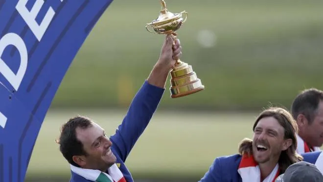 Europe's Francesco Molinari holds up the trophy while his teammate Tommy Fleetwood looks on after the European team won the 2018 Ryder Cup golf tournament at Le Golf National in Saint Quentin-en-Yvelines, outside Paris, France, Sunday, Sept. 30, 2018. (ANSA/AP Photo/Alastair Grant) [CopyrightNotice: Copyright 2018 The Associated Press. All rights reserved]