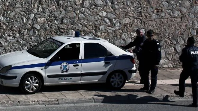 Police stand outside Korydallos Prison in Athens, the largest penitentiary in Greece, on November 21, 2014. Authorities have announced that inmates had smashed parts of the facility�s ground floor, after rioting began on November 21 following the detention of a visitor, for allegedly attempting to smuggle drugs. AFP PHOTO / Angelos Tzortzinis