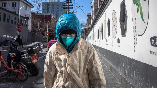 epa08237038 A woman wearing a protective face mask walks around Beijing, China, 22 February 2020. The novel coronavirus (SARS-CoV-2) outbreak, which originated in the Chinese city of Wuhan, has so far killed more than 2,000 people with over 77,000 infected worldwide, mostly in China.  EPA/ROMAN PILIPEY