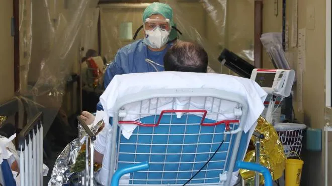 Un'infermiera con un paziente al pronto soccorso check point sanitario per il coronavirus, presso l'isituto ospedaliero Fondazione Poliambulanza, Brescia 16 marzo 2020. 
ANSA/FILIPPO VENEZIA