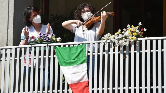 People sing 'Bella Ciao' on the balcony due to the coronavirus emergency to celebrate Italy's Liberation Day, Turin, 25 April 2020. ANSA/ALESSANDRO DI MARCO