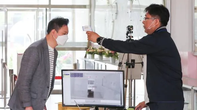 epa08444173 Teachers check a thermal scanner at Gyenam Elementary School in Seoul, South Korea, 26 May 2020. Millions of students throughout South Korea are expected to return to school on 27 May as the country gradually lifts coronavirus restrictions.  EPA/YONHAP SOUTH KOREA OUT