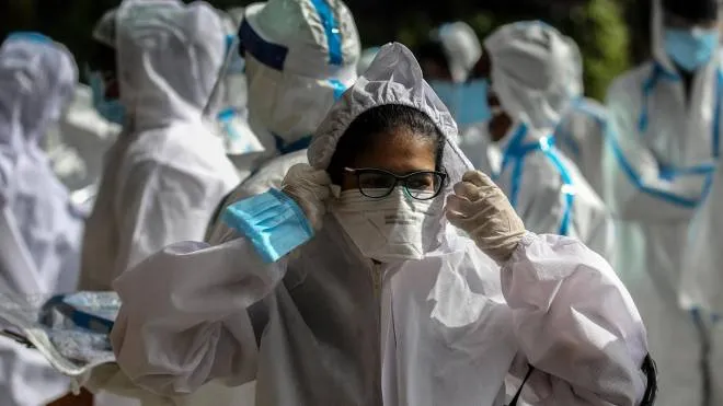 epa08522770 Indian health workers wearing personal protective equipment (PPE) gathered to carry medical checkup of the residents of a 'containment zones' in Mumbai, India, 02 July 2020. According to media reports, the state government of Maharashtra extended the lockdown till 31 July, with some relaxation in the ongoing lockdown.  EPA/DIVYAKANT SOLANKI