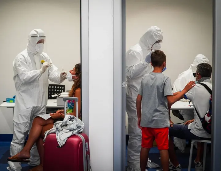 Controlli anti Coronavirus ai passeggeri che transitano dall’aeroporto Capodichino di Napoli. Sotto, il virologo Giorgio Palù