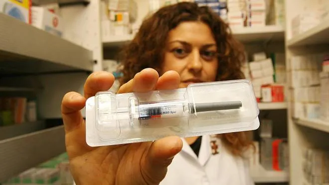 Una farmacista mostra un vaccino antinfluenzale. La campagna di quest’anno partirà in anticipo