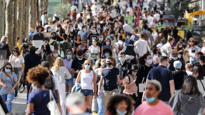 People wearing face masks walk on the Champs Elysees Avenue in Paris, on August 27, 2020. - France's prime minister announced on August 27, 2020, that face masks become compulsory throughout Paris and inner suburbs as he detailed a national trend of expanding coronavirus infections. (Photo by Ludovic MARIN / AFP)