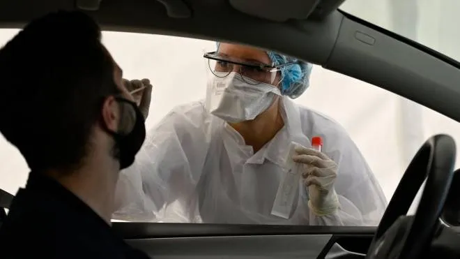 A health official collects a nasal swab sample from a man for a Covid-19 coronavirus test in a "Covid Drive" at the University Hospital Center (CHU) in Rennes, western France, on September 7, 2020. (Photo by Damien MEYER / AFP)