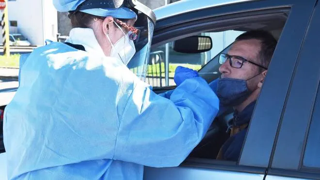 Un’infermiera esegue un tampone in uno dei drive-in allestiti in Italia per raccogliere più velocemente i campioni