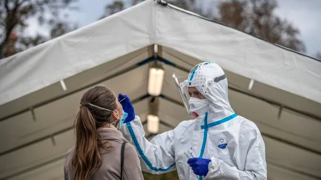 epa08729184 A medical worker wearing personal protective equipment (PPE) takes a swab sample from a person at a newly opened drive-in coronavirus testing station in Prague, Czech Republic, 08 October 2020. The Czech government declared a state of emergency from 05 October 2020 due to a recent spike in newly detected coronavirus COVID-19 infections.  EPA/MARTIN DIVISEK