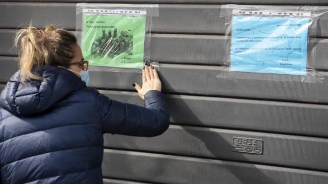 Una addetta affigge i cartelli all'esterno di una sala Bingo chiusa a seguito dell'ultimo Dpcm, Roma 26 ottobre 2020.   MAURIZIO BRAMBATTI/ANSA