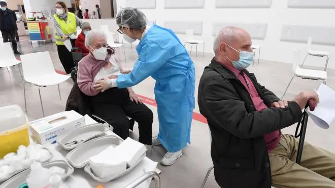 A healthcare personnel speaks with an enderly person before administratea dose of the Covid-19 vaccine at a vaccination center in Binasco, near Milan, Italy, 25 March 2021. ANSA/DANIEL DAL ZENNARO