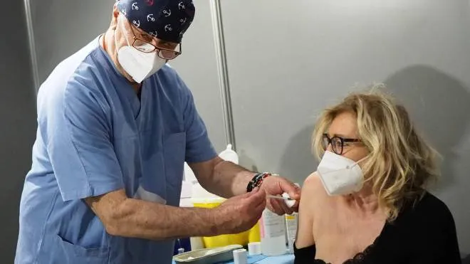 Un operatore inietta una dose di vaccino anti Coronavirus su una paziente in uno dei centri abilitati
