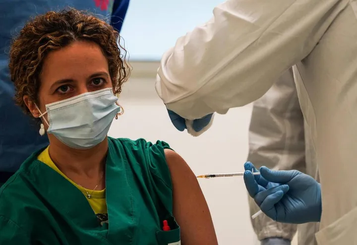 Un’operatrice sanitaria si sottopone al vaccino anti Covid