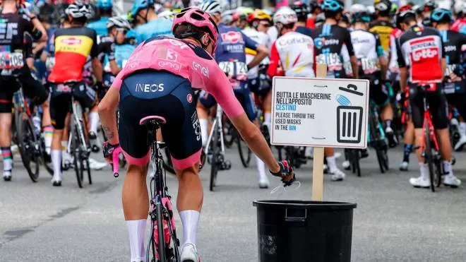 Team Ineos rider Italy's Filippo Ganna, wearing the overall leader's pink jersey, throws away his face mask in a bin prior to the start of the second stage of the Giro d'Italia 2021 cycling race, 179 km between Stupinigi and Novara on May 9, 2021. (Photo by Luca Bettini / AFP)