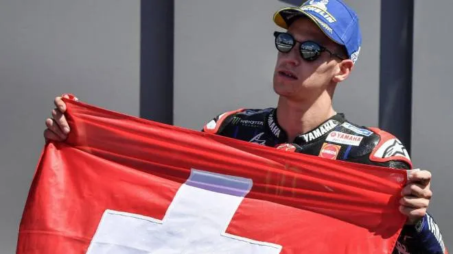 Yamaha French rider Fabio Quartararo poses with a Swiss national flag in tribute to Swiss Moto3 rider Jason Dupasquier, who died aged 19 from injuries sustained in a crash in qualifying, after winning the moto world championship Italian Grand Prix MotoGP race at the Mugello racetrack on May 30, 2021. (Photo by Tiziana FABI / AFP)