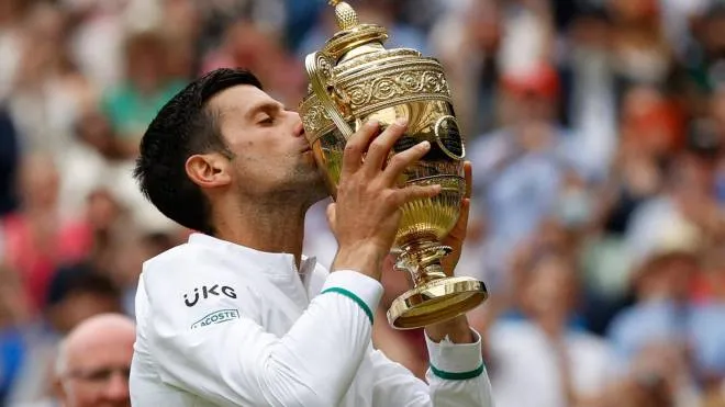 Serbia's Novak Djokovic kisses the winner's trophy after beating Italy's Matteo Berrettini during their men's singles final match on the thirteenth day of the 2021 Wimbledon Championships at The All England Tennis Club in Wimbledon, southwest London, on July 11, 2021. (Photo by Adrian DENNIS / AFP) / RESTRICTED TO EDITORIAL USE