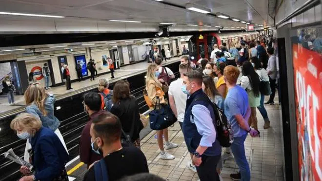 Passengers wait on the platform as they travel on the London Underground in central London on July 14, 2021. - London Mayor Sadiq Khan called for use of face coverings to remain compulsory on public transport in the British capital after government plans to relax Covid curbs begin on July 19. (Photo by JUSTIN TALLIS / AFP)