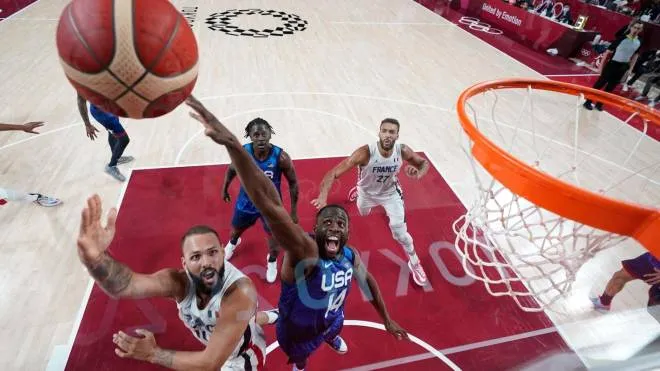 France's Evan Fournier goes for the basket past USA's Zachary Lavine (2L) Draymond Jamal Green (3L) during the men's preliminary round group A basketball match between France and USA during the Tokyo 2020 Olympic Games at the Saitama Super Arena in Saitama on July 25, 2021. (Photo by Eric GAY / various sources / AFP)