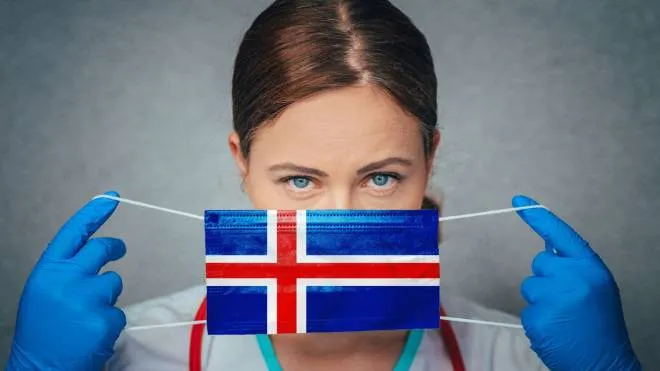 Sabattini Iceland Covid
 - Coronavirus in Iceland Female Doctor Portrait hold protect Face surgical medical mask with Iceland National Flag. Illness, Virus Covid-19 in Iceland, concept photo