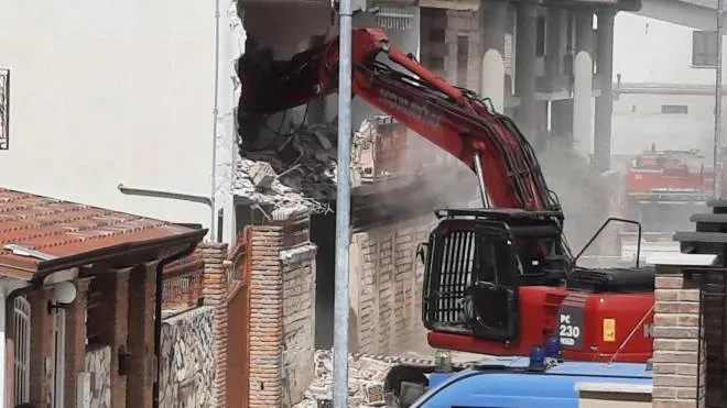Una ruspa demolisce i muri dell’immobile di via Ancona, non lontano dal centro