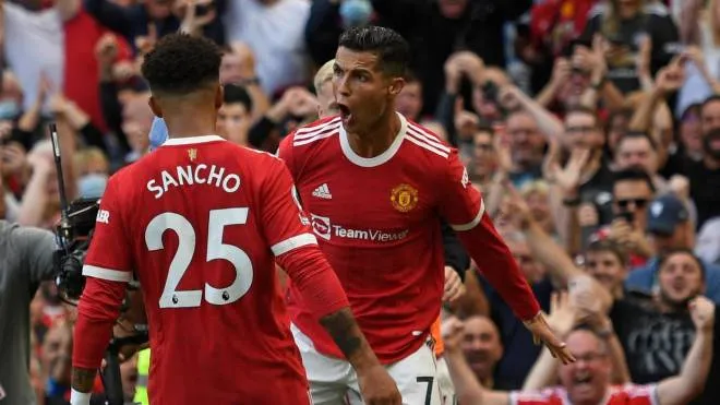 Manchester United's Portuguese striker Cristiano Ronaldo (R) celebrates with Manchester United's English striker Jadon Sancho (L) after scoring their second goal during the English Premier League football match between Manchester United and Newcastle at Old Trafford in Manchester, north west England, on September 11, 2021. (Photo by Oli SCARFF / AFP) / RESTRICTED TO EDITORIAL USE. No use with unauthorized audio, video, data, fixture lists, club/league logos or 'live' services. Online in-match use limited to 120 images. An additional 40 images may be used in extra time. No video emulation. Social media in-match use limited to 120 images. An additional 40 images may be used in extra time. No use in betting publications, games or single club/league/player publications. /