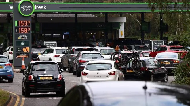Motorists queue for petrol and diesel fuel at a petrol station off of the M3 motorway near Fleet, west og London on September 26, 2021. - Britain's transport secretary Grant Shapps on Sunday accused lorry industry representatives of helping to spark petrol panic-buying, as he defended a U-turn on post-Brexit immigration policy to ease an escalating supply crisis. (Photo by Adrian DENNIS / AFP)