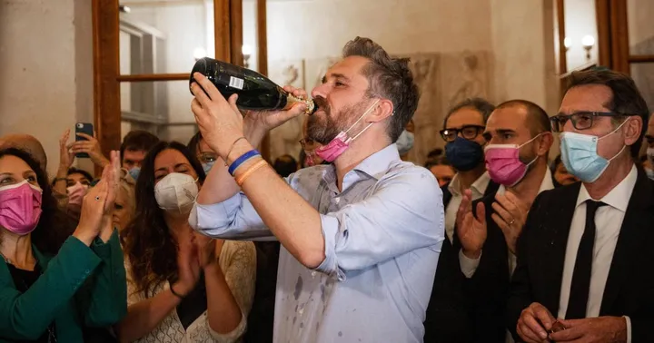 Matteo Lepore, 41 anni, festeggia la vittoria a palazzo D’Accursio. A destra il suo predecessore Virginio Merola, 66