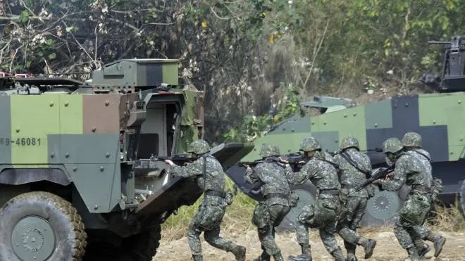 (FILES) In this file photo taken on January 17, 2017 Taiwan special forces personnel walk behind an armoured personnel carrier during an annual military drill in Taichung, central Taiwan. - US special operations forces and marines have been secretly training Taiwanese troops for more than one year, risking the ire of China, the Wall Street Journal reported on October 7, 2021. (Photo by SAM YEH / AFP)