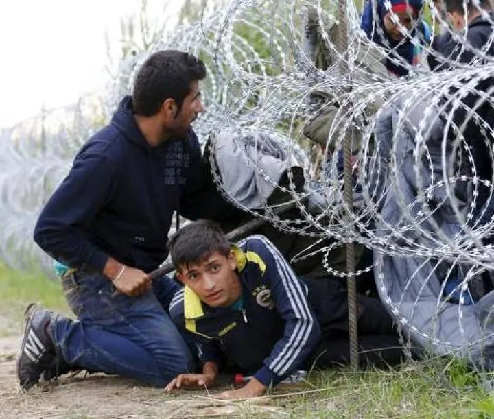 Alcuni migranti tentano di oltrepassare il filo spinato al confine ungherese