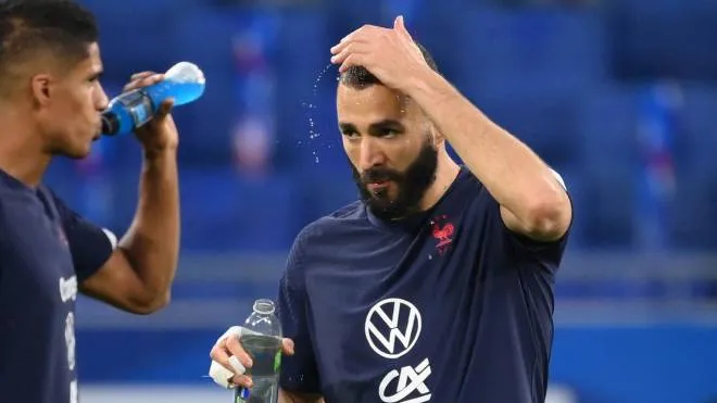 (FILES) In this file photo taken on September 07, 2021 France's forward Karim Benzema pours water on his head before the FIFA World Cup Qatar 2022 Group D qualification football match between France and Finland at the Groupama stadium in Decines-Charpieu near Lyon, central eastern France. - A French court on November 24, 2021 gave Real Madrid striker Karim Benzema a one-year suspended sentence for complicity in a bid to blackmail his former France team-mate Mathieu Valbuena with a sex tape. (Photo by FRANCK FIFE / AFP)